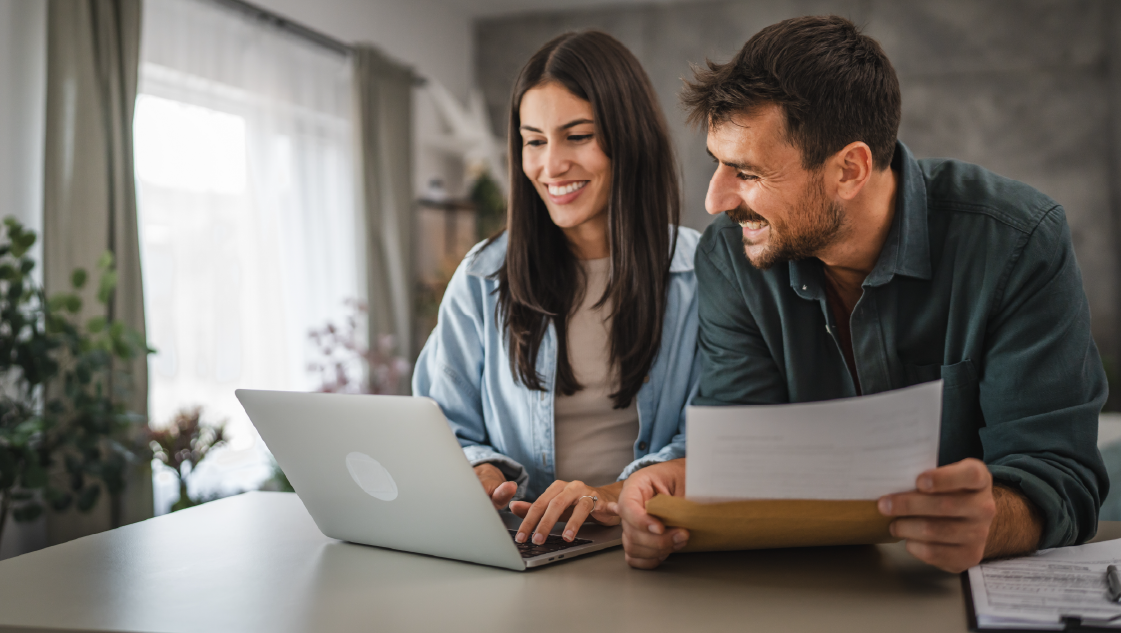 Pareja feliz, con portatil y documentos